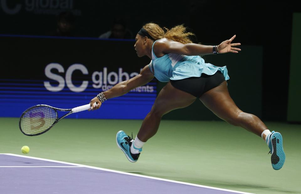 Serena Williams of the U.S. hits a return to Caroline Wozniacki of Denmark during their WTA Finals singles semi-final tennis match at the Singapore Indoor Stadium