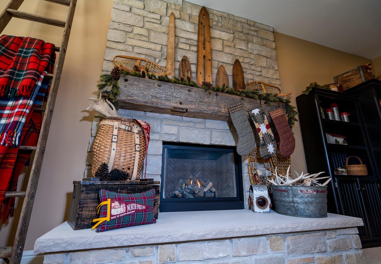 One of Julie Hunt's fireplaces is decorated with snowshoes, Christmas stockings and a pillow she made with an antique pendant.