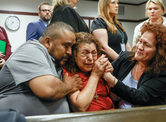 Tampa, Florida, USA. 28th Mar, 2023. Alejandro Corona Garcia, left, and Paz Quezada, center, who is the mother of Juan and Sergio Guitron, and victim advocate Stella Carabine, right, share a moment after a guilty verdict is read in the retrial of Michael (Ivy Ceballo / Tampa Bay Times via ZUMA / Alamy)