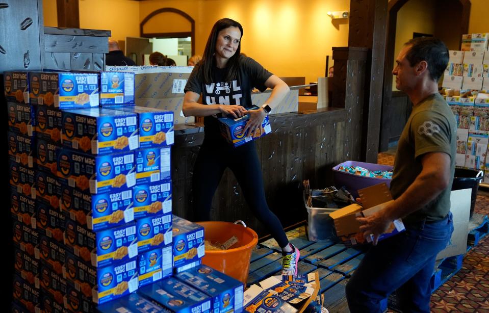 Ashley Kanney, founder of Feed the Kids Columbus, helps to break down boxes during a blessing bag packing event at the former Montgomery Inn in Dublin.