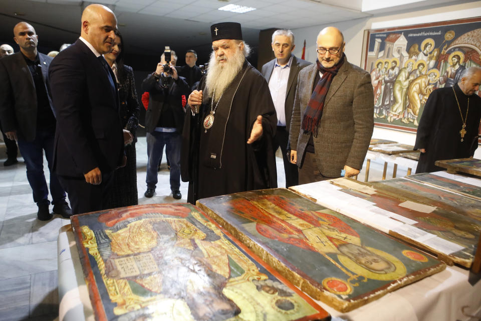 North Macedonia's Prime Minister Dimitar Kovacevski, left, the Orthodox Archbishop Stefan, center and Sasho Cvetkovski, member of the Academy of Sciences of North Macedonia, right, review icons returned from Albania at the National museum in Skopje, North Macedonia, late Friday, Dec. 15, 2023. Albania on Friday returned 20 icons to neighboring North Macedonia that were stolen a decade ago. (AP Photo/Boris Grdanoski)