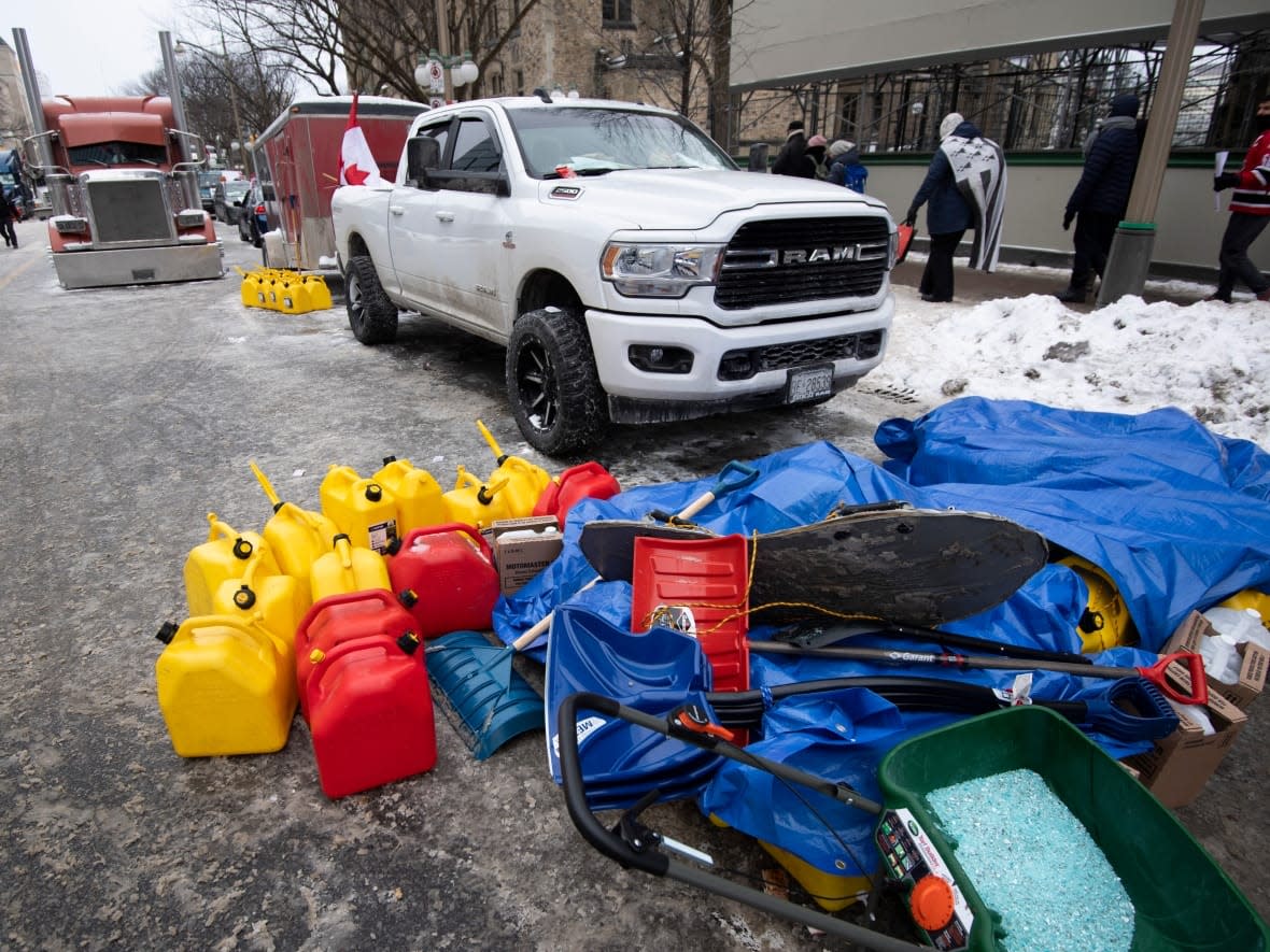 Fuel containers, charcoal briquettes, snow shovels and ice salt are piled in front of a vehicle on Feb. 6, 2022, as a protest against COVID-19 restrictions in Ottawa enters its second week. Ottawa police said Sunday they would begin cutting off fuel, food and other supplies from reaching the protesters in the downtown core.  (Justin Tang/The Canadian Press - image credit)