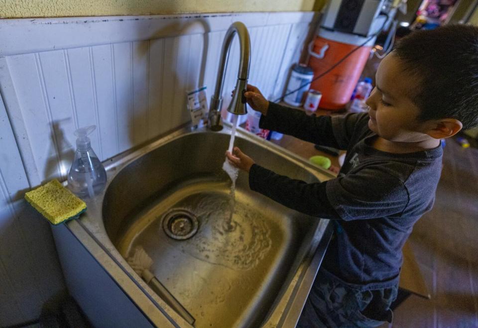 Alex Etsitty, 4, washes his hands inside his Navajo Nation home.