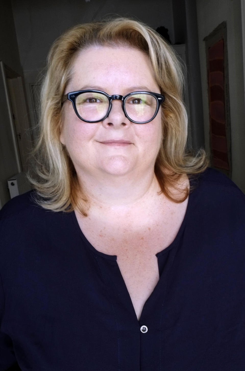 A headshot of Magda Szubanski wearing glasses and a black shirt