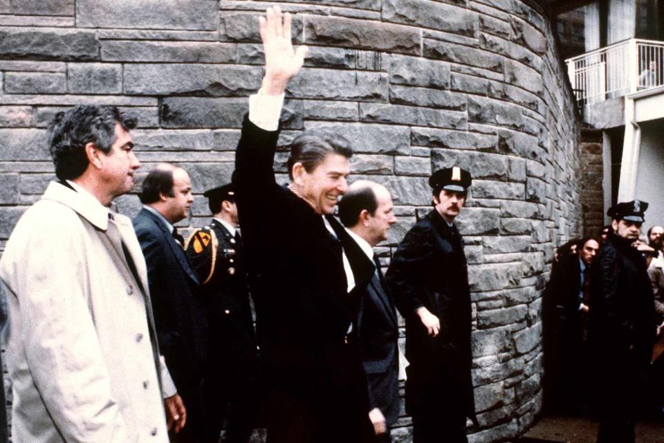 <p>MIKE EVENS/CONSOLIDATED NEWS PICTURES/AFP via Getty</p> President Ronald Reagan waves to a Washington, D.C., crowd moments before being shot in the chest on March 30, 1981