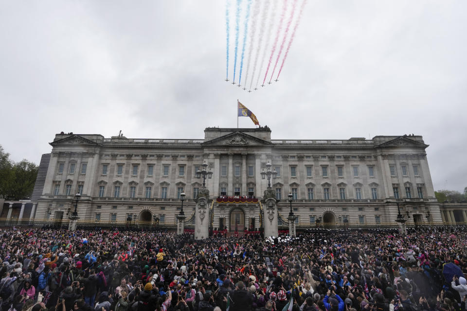 Las Flechas Rojas de la Real Fuerza Aérea de Gran Bretaña vuelan sobre el Palacio de Buckingham mientras el rey Carlos III y la reina Camila saludan a la multitud desde el balcón del palacio luego de la ceremonia de coronación, en Londres, el sábado 6 de mayo de 2023. (AP Foto/Frank Augstein)