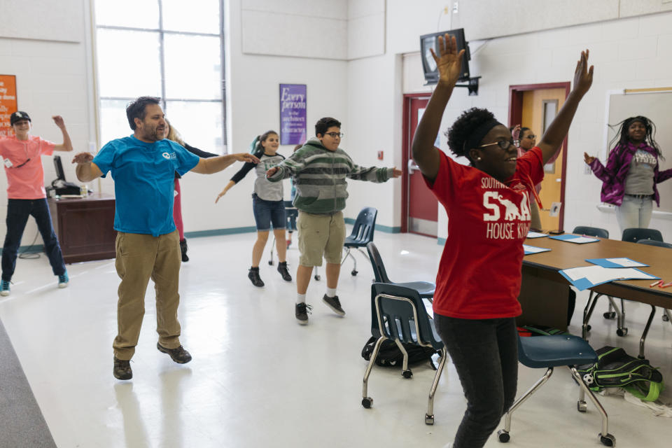 In this Oct. 20, 2017 photo provided by Deep Center, authors and mentors use movement and play to kick off a Deep Center workshop at Southwest Middle School in Savannah, Ga. Deep Center works with young writers to share their stories with policy makers, judges, politicians, police officers and the like. (Laura Mulder/Deep Center via AP)