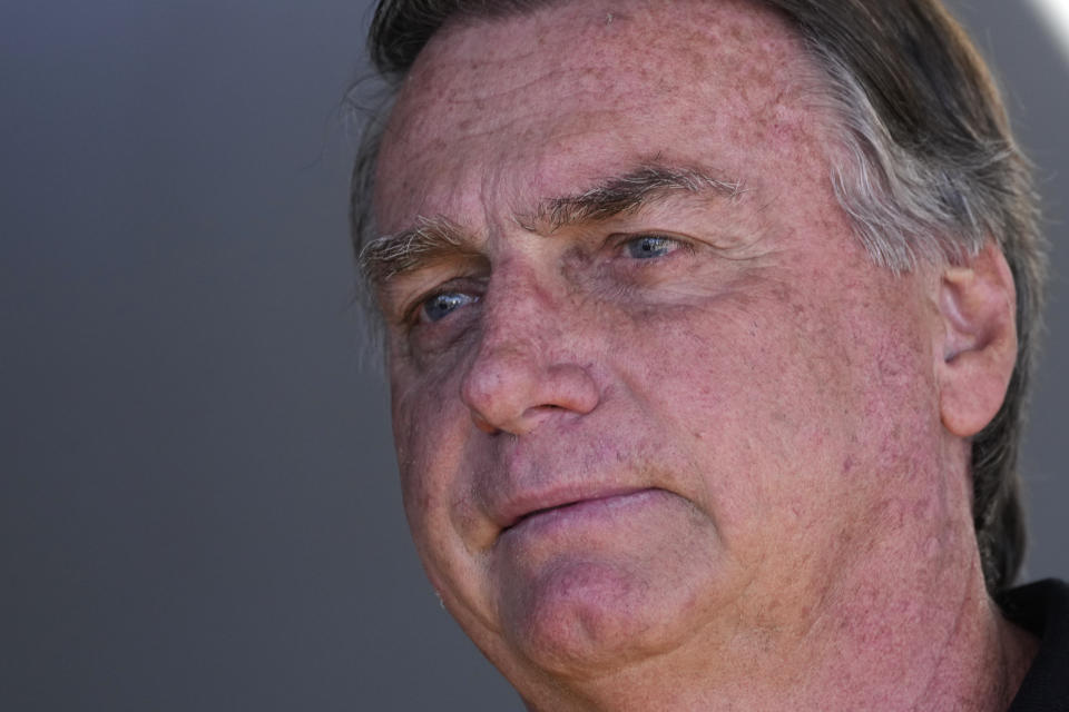 Former Brazilian President Jair Bolsonaro talks with supporters during his arrival to the international airport in Brasilia, Brazil, Friday, July 5, 2024. Brazilian police have indicted Bolsonaro for money laundering and criminal association in connection with undeclared diamonds the far-right leader received from Saudi Arabia during his time in office, according to a source with knowledge of the accusations. (AP Photo/Eraldo Peres)