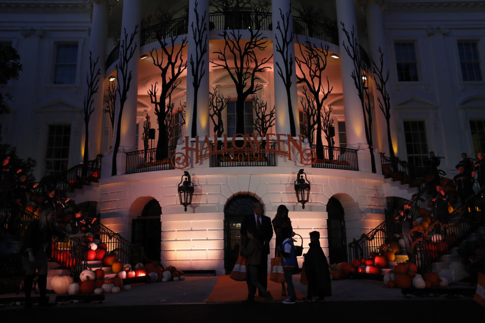 President Donald Trump and first lady Melania Trump give candy to children during a Halloween trick-or-treat event on the South Lawn of the White House which is decorated for Halloween, Monday, Oct. 28, 2019, in Washington. (AP Photo/Alex Brandon)