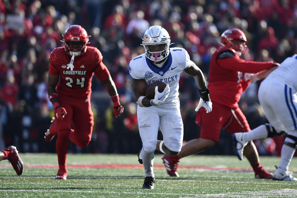 Kentucky running back Ray Davis (1) runs from the pursuit of the Louisville defense during the second half of an NCAA college football game in Louisville, Ky., Saturday, Nov. 25, 2023. Kentucky won 38-31. (AP Photo/Timothy D. Easley)