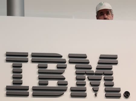 A worker is pictured behind a logo at the IBM stand on the CeBIT computer fair in Hanover February 26, 2011. The world's largest IT fair CeBIT opens its doors on March 1 and runs through March 5. REUTERS/Tobias Schwarz