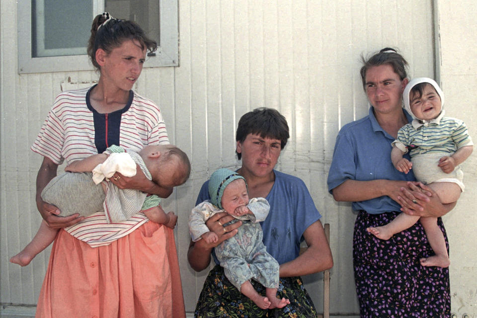 FILE- In this July 22, 1995, file picture, Bosnian refugee women from the area of Srebrenica line up waiting to bathe their babies at the UNICEF baby wash room at the U.N. air base, in Tuzla, Bosnia. Survivors of the genocide in the eastern Bosnian town of Srebrenica, mainly women, will on Saturday July 11, 2020, commemorate the 25th anniversary of the slaughter of their fathers and brothers, husbands and sons. At least 8,000 mostly Muslim men and boys were chased through woods in and around Srebrenica by Serb troops in what is considered the worst carnage of civilians in Europe since World War II. The slaughter was also the only atrocity of the brutal war that has been confirmed an act of genocide.(AP Photo/Michel Euler, File)