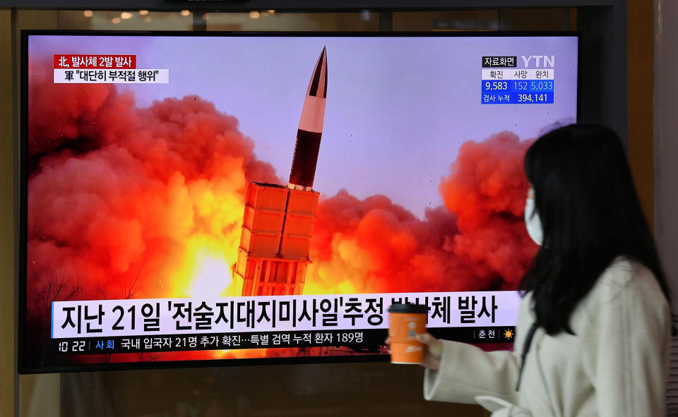 A woman walks past a screen showing file footage of a North Korean missile test, at a railway station in Seoul on March 29<span class="copyright">Jung Yeon-Je—AFP/Getty Images</span>