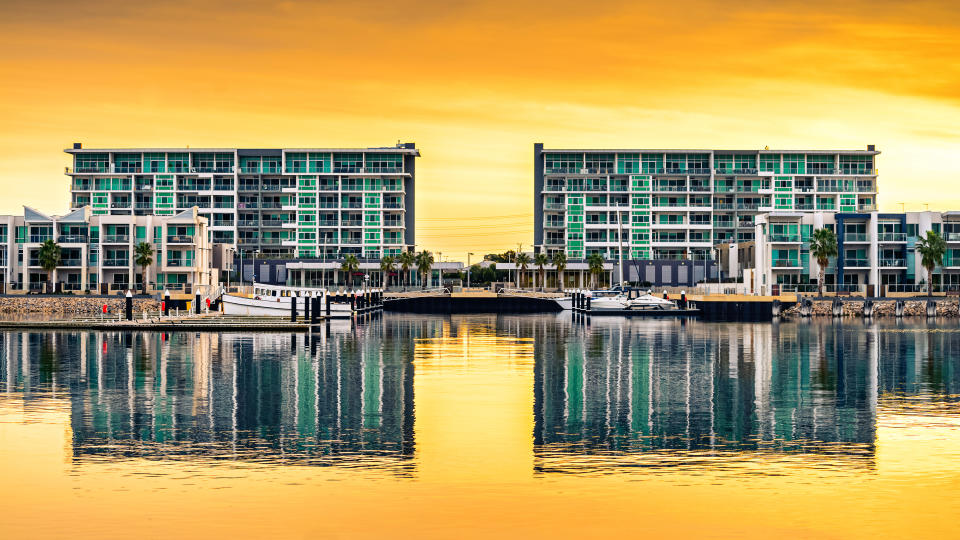 Wirra Drive apartment buildings reflecting in the river at New Port at sunset, Port Adelaide, South Australia