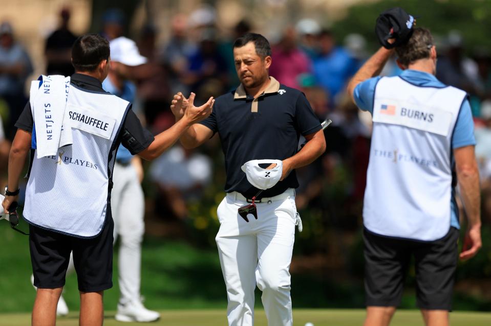 Xander Schauffele high-fives his caddie Austin Kaiser after completing for the day on the ninth hole during the first round of The Players Championship on Thursday.