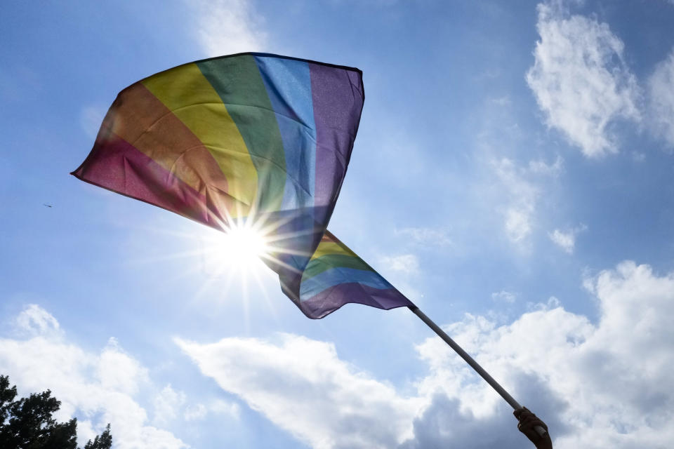 A woman waves a rainbow flag , during the annual pride march in Berlin, Germany, Saturday, July 23, 2022. Draped in rainbow flags, around 150,000 people were marching for LGBTQ rights at Berlin's annual Christopher Street Day celebration. Berlin police gave the crowd estimate on Saturday afternoon but said the number could grow into the evening. (AP Photo/Markus Schreiber)