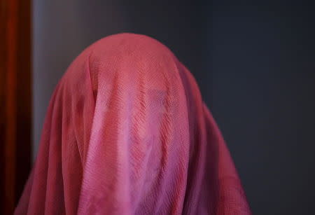 The veiled mother of Meenakshi Kumari, 23, one of the two sisters allegedly threatened with rape by a village council in the northern Indian state of Uttar Pradesh, stands inside her house at Sankrod village in Baghpat district, India, September 1, 2015. REUTERS/Adnan Abidi