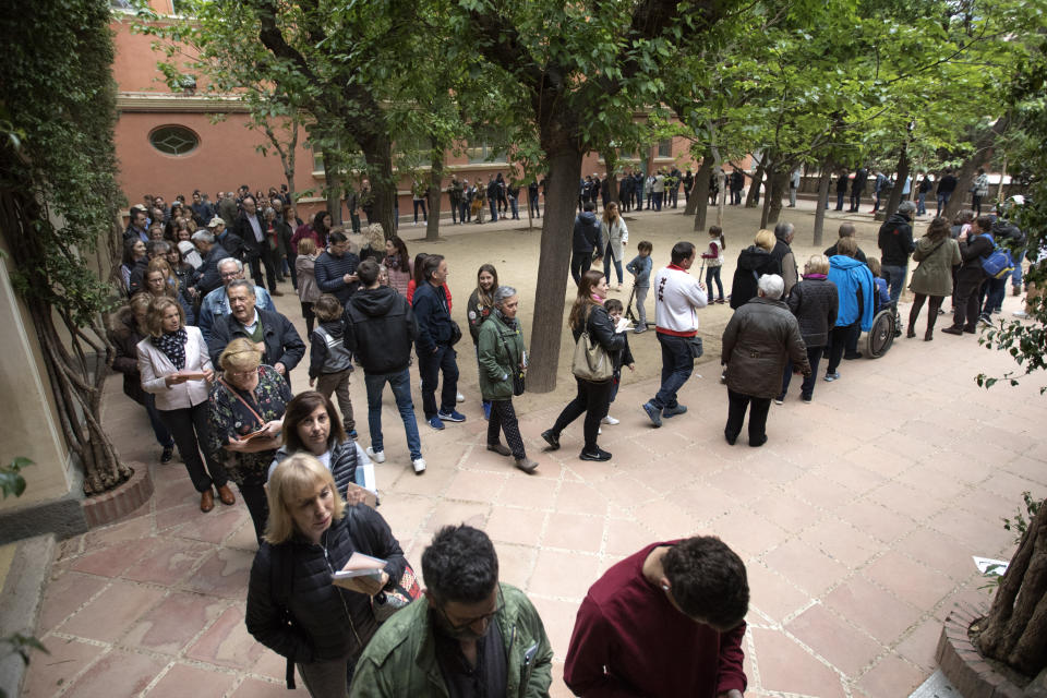 People line up to cast their votes during Spain's general election in a polling station in Barcelona, Spain, Sunday, April 28, 2019. A divided Spain is voting in its third general election in four years, with all eyes on whether a far-right party will enter Parliament for the first time in decades and potentially help unseat the Socialist government. (AP Photo/Emilio Morenatti)