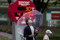 FILE - In this Wednesday, June 23, 2021, file photo, a countdown clock shows 30 days to the opening ceremony of the Tokyo 2020 Olympic and Paralympic Games, in Tokyo. After months of delays due to political and bureaucratic bungling as well as a shortage of vaccines, inoculations in Japan are taking off, and the drive is now racing down to the wire with the Olympics starting in one month. (AP Photo/Kiichiro Sato, File)