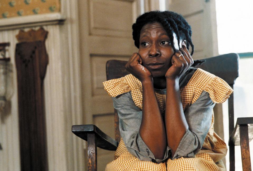 Whoopi Goldberg sits in a chair in character as Celie in the 1985 film, "The Color Purple."