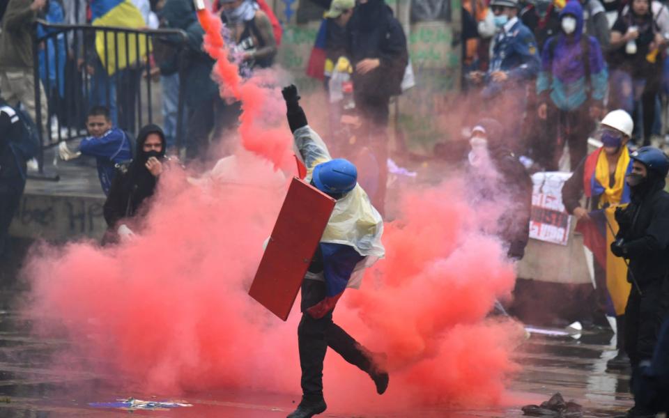 Demonstrators clash with riot police during a protest against President Ivan Duque's government at the Bolivar square in Bogota - JUAN BARRETO /AFP