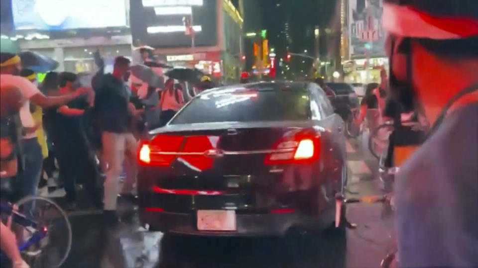 In this frame grab from a video by @datainput from the New York City Police Department Twitter account, a car moves through protesters, in New York's Times Square, Thursday, Sept, 3, 2020. The New York Police Department says it is trying to find the car that drove through a group of Black Lives Matter protesters blocking a street in Times Square. The NYPD said on Twitter that the car wasn't a police vehicle. (New York City Police Dept. via AP)