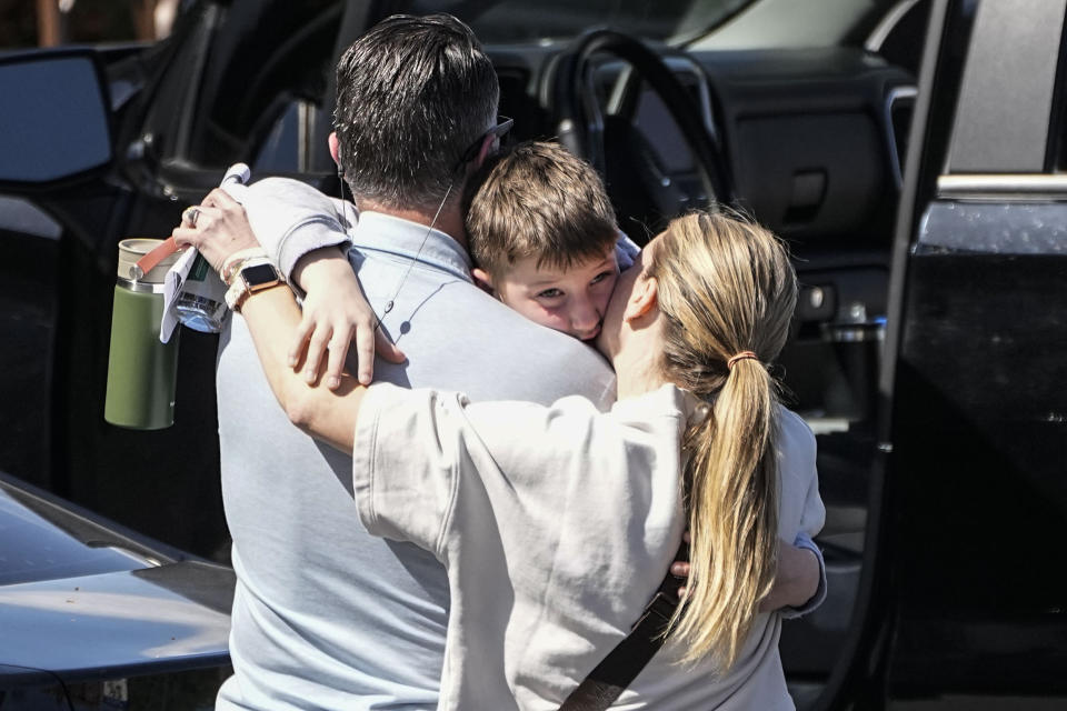 A woman kisses a child at the reunification center at the Woodmont Baptist church after a school shooting, Monday, March 27, 2023, in Nashville, Tenn. Source: AP via AAP