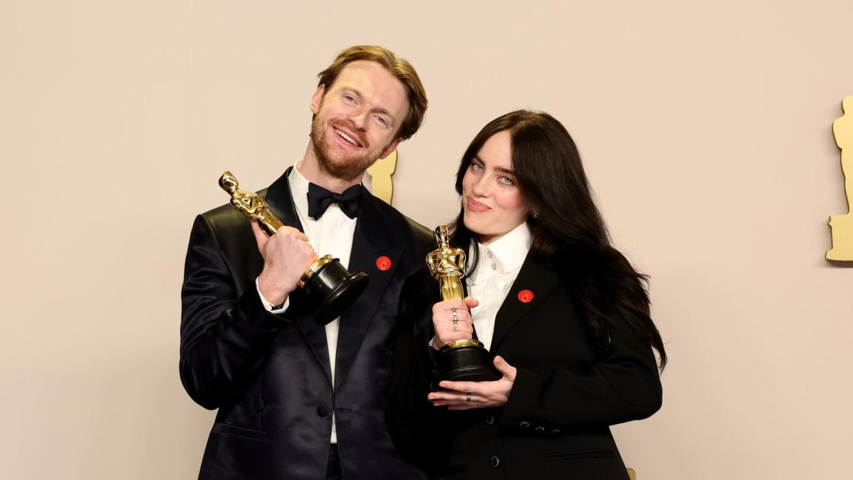 billie eilish and brother finneas o connell holding oscar trophies