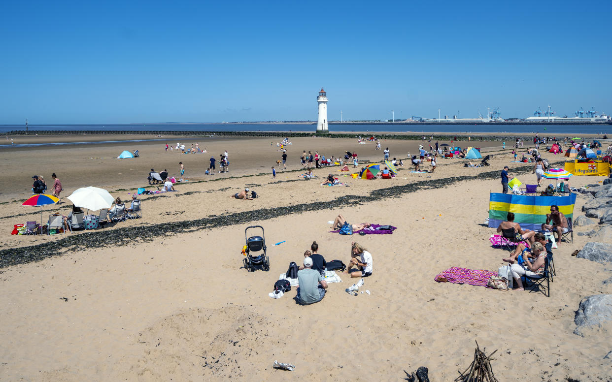 Sunbathers make the most of the mini heatwave in New Brighton, Wirral, on what could be the hottest day of the year. Picture date: Saturday July 17, 2021.