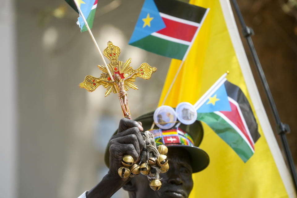 A man holds religious articles and South Sudan flags as Pope Francis meets with priests, deacons, consecrated people and seminarians at the Cathedral of Saint Theresa in Juba, South Sudan, Saturday, Feb. 4, 2023. Francis is in South Sudan on the second leg of a six-day trip that started in Congo, hoping to bring comfort and encouragement to two countries that have been riven by poverty, conflicts and what he calls a "colonialist mentality" that has exploited Africa for centuries. (AP Photo/Gregorio Borgia)