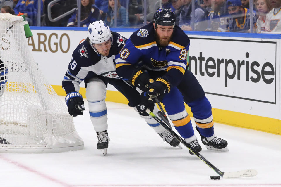 Winnipeg Jets Mark Scheifele (55) pokes the puck away from St. Louis Blues center Ryan O'Reilly (90) during the second period of an NHL hockey game Sunday, Dec. 29, 2019, in St. Louis. (AP Photo/Dilip Vishwanat)