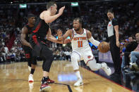 New York Knicks guard Jalen Brunson (11) drives to the basket as Miami Heat forward Duncan Robinson, left, defends during the first half of an NBA basketball game, Tuesday, April 2, 2024, in Miami. (AP Photo/Lynne Sladky)