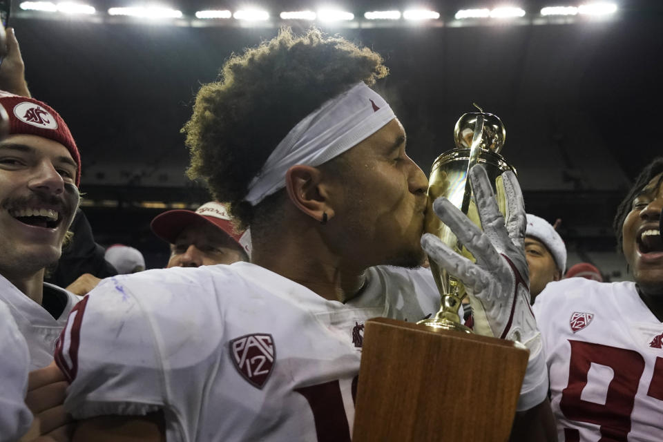 Washington State defensive end Ron Stone Jr. kisses the Apple Cup Trophy after defeating Washington in an NCAA college football game, Friday, Nov. 26, 2021, in Seattle. (AP Photo/Ted S. Warren)