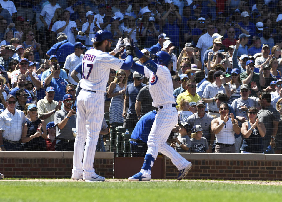 Chicago Cubs' Javier Baez, right, is greeted by Kris Bryant, left, after hitting a two-run home run against the Milwaukee Brewers during the third inning of a baseball game, Friday, Aug. 2, 2019, in Chicago. (AP Photo/David Banks)