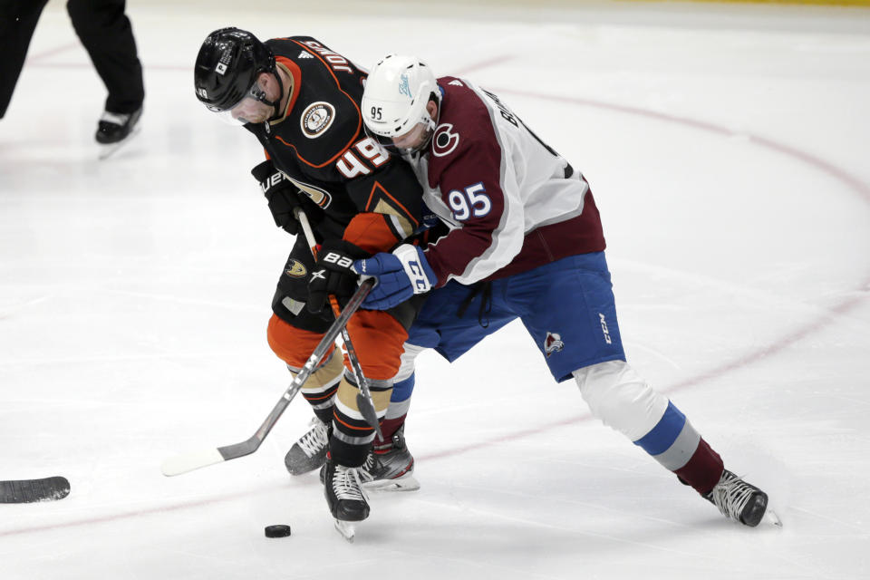 Anaheim Ducks left wing Max Jones, left, competes for the puck with Colorado Avalanche left wing Andre Burakovsky during the third period of an NHL hockey game in Anaheim, Calif., Sunday, Jan. 24, 2021. (AP Photo/Alex Gallardo)