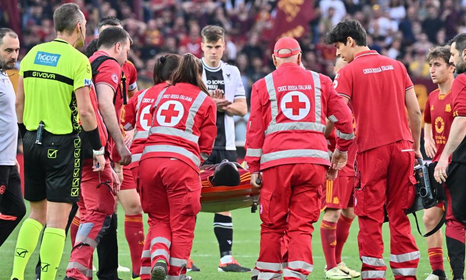 <span>Evan Ndicka is carried off on a stretcher after collapsing in the match against <a class="link " href="https://sports.yahoo.com/soccer/teams/udinese/" data-i13n="sec:content-canvas;subsec:anchor_text;elm:context_link" data-ylk="slk:Udinese;sec:content-canvas;subsec:anchor_text;elm:context_link;itc:0">Udinese</a>. Roma later said their defender was ‘in good spirits’ in hospital. </span><span>Photograph: Xinhua/Shutterstock</span>