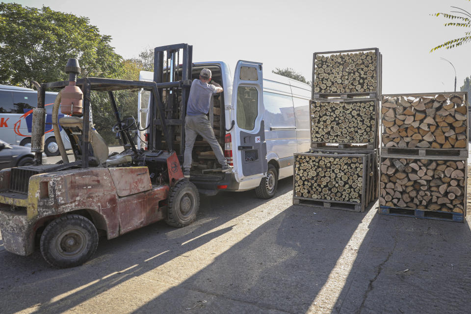 A firewood vendor loads a pallet into a van outside Chisinau, Moldova, Saturday, Oct. 15, 2022. Europe's energy crisis, triggered by Russia slashing natural gas flows amid its war against Ukraine, has forced some people to turn to cheaper heating sources like firewood as the weather gets colder. But as more people stock up and burn wood, prices have skyrocketed, shortages and thefts have been reported, and scams are emerging. (AP Photo/Aurel Obreja)