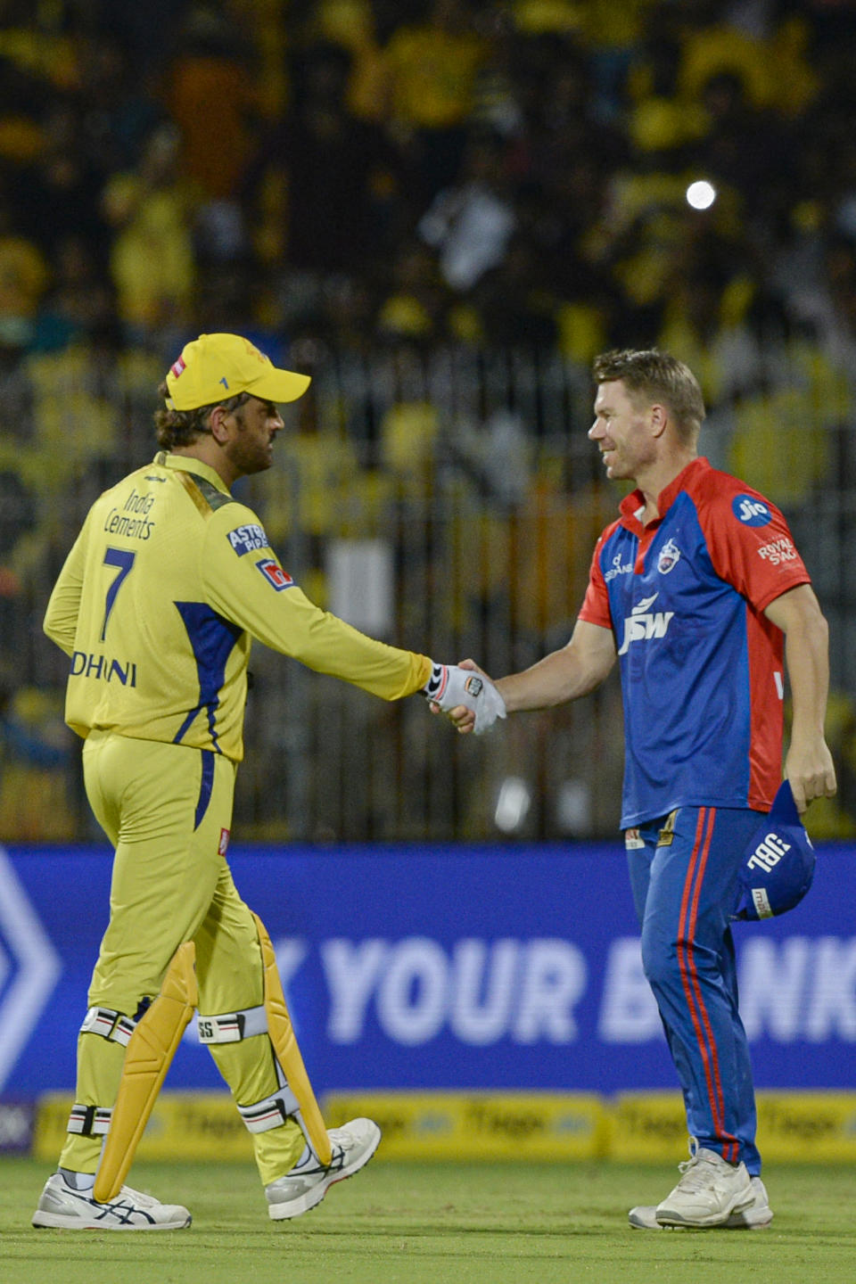 Mahendra Singh Dhoni shakes hands with David Warner.