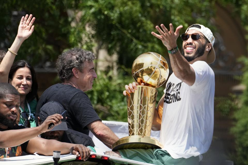 Boston Celtics' Jayson Tatum, right, and Celtics owner Wyc Grousbeck, center, celebrate their NBA basketball championship with a duck boat parade Friday, June 21, 2024, in Boston. (AP Photo/Michael Dwyer)