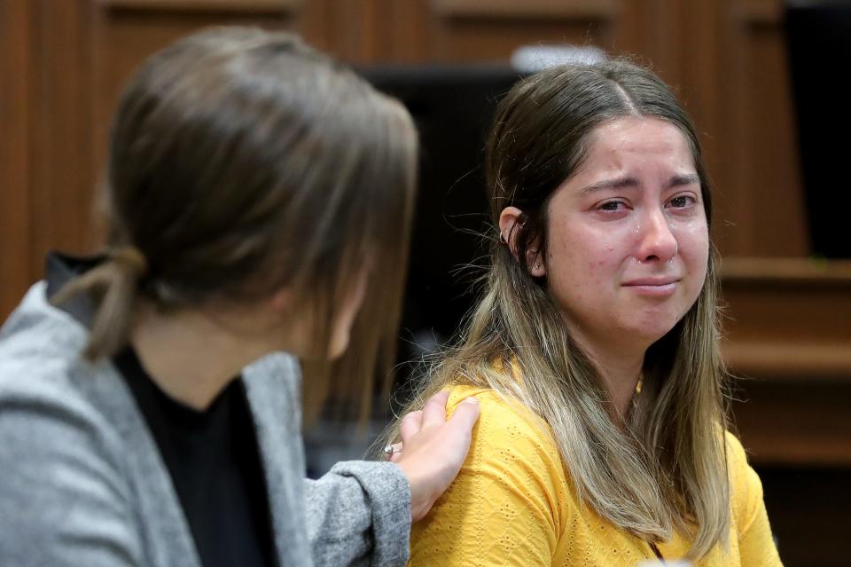 Sydney Powell is comforted by paralegal Marie DiCola during the start of Powell's murder trial Thursday for the stabbing death of her mother.