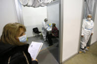 A medical worker gives a shot of Chinese Sinopharm COVID-19 vaccine to a woman during the vaccination in Belgrade, Serbia, Wednesday, Feb. 17, 2021. Serbian health expert Chief epidemiologist Predrag Kon on Tuesday March 2, 2021, called for the government to introduce a state of emergency and a strict lockdown to halt a surge in coronavirus infections in the Balkan country. (AP Photo/Darko Vojinovic)