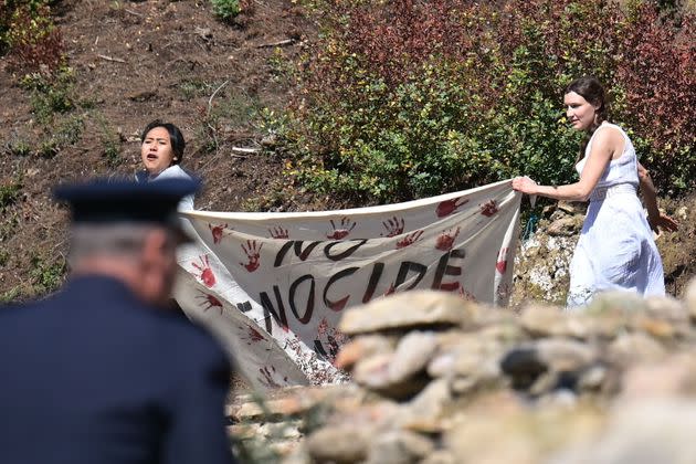 A police officer rushes to stop protesters holding a banner and the Tibetan flag (unseen) as they crash the start of the flame lighting ceremony for the Beijing 2022 Winter Olympics at the Ancient Olympia archeological site.  (Photo: ARIS MESSINIS via Getty Images)