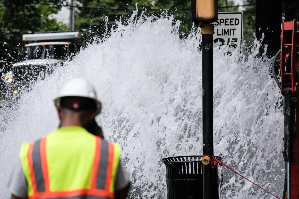 A crew member walks near a broken water transmission line, Saturday, June 1, 2024, in Atlanta. Much of Atlanta, including all of downtown, has been without water since Friday afternoon after crews began work to repair breaks on transmission lines in the downtown area. (AP Photo/Mike Stewart)