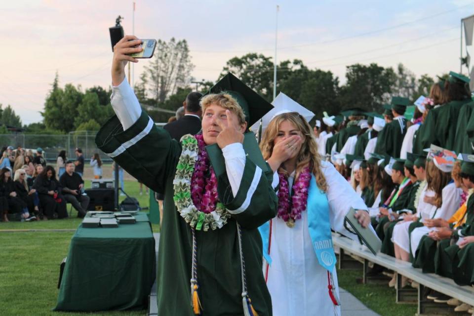 Harper Clark takes a selfie as Eliana Cunningham laughs after walking across the stage at Templeton High School’s graduation ceremony at Volunteer Stadium on June 8.