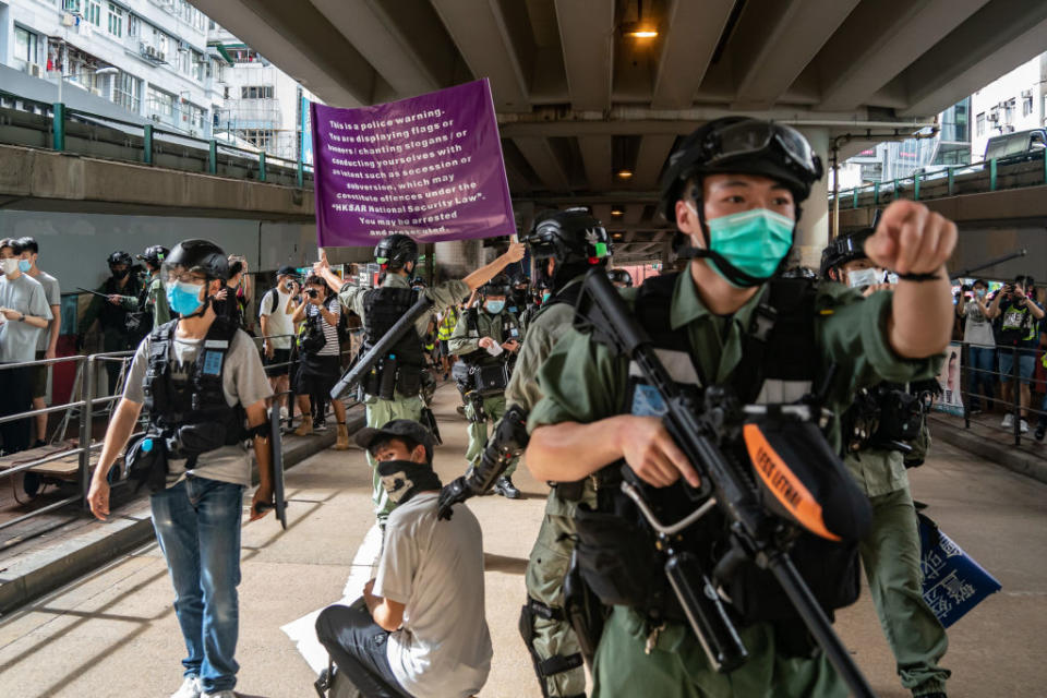 Police detain a man as they raise a warning flag during a demonstration against the new national security law in Hong Kong on July 1, 2020. | Getty Images—2020 Getty Images