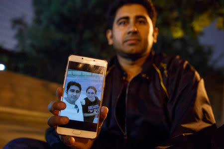 Pakistani businessman Mirza Imran Baig shows a picture of him and his wife Mailikemu Maimati as he sits outside the Pakistani embassy in Beijing, China, September 25, 2018. REUTERS/Thomas Peter