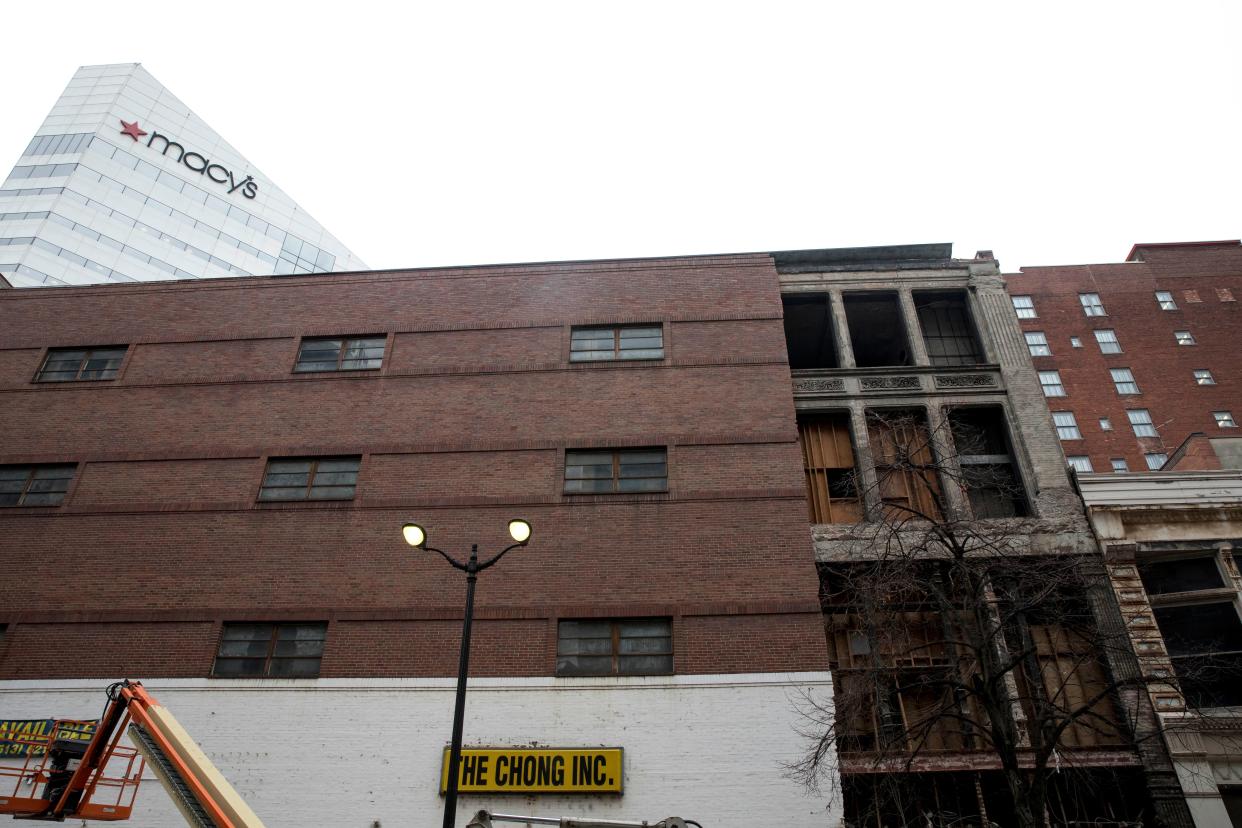 Crews removed some of the brick exterior of the building at 616 Race Street exposing the Victorian era storefront on Wednesday, Jan. 27, 2021, in Cincinnati. The Chong Inc., which was the most recent tenant, closed last March due to the new coronavirus pandemic.