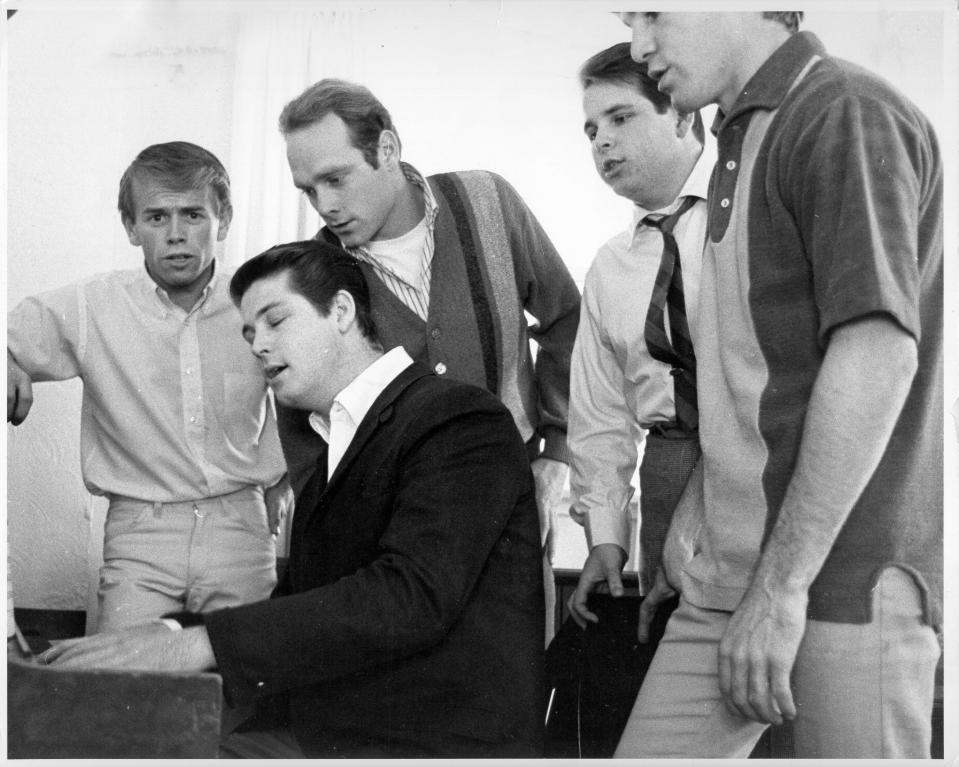 (From left): Al Jardine, Brian Wilson, Mike Love, Carl Wilson and Dennis Wilson of The Beach Boys sing around a piano circa 1964.