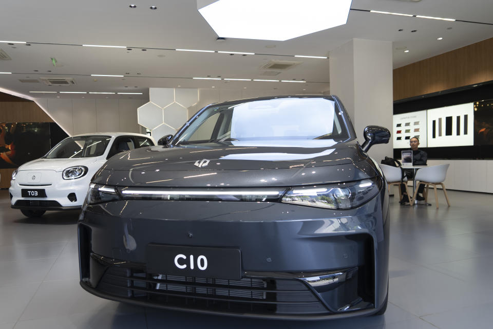 A man sits near the Leapmotor C10 model displayed at a showroom in Hangzhou in eastern China's Zhejiang province on Tuesday, May 14, 2024. European carmaker Stellantis on Tuesday said it had formed a joint venture with the Chinese electric vehicle startup Leapmotor that will begin selling EVs in nine European countries later this year. (AP Photo/Caroline Chen)