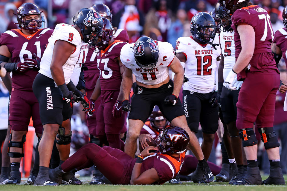 Nov 18, 2023; Blacksburg, Virginia, USA; North Carolina State Wolfpack linebacker Payton Wilson (11) reacts over Virginia Tech Hokies quarterback Kyron Drones (1) after a sack during the first quarter at Lane Stadium. Mandatory Credit: Peter Casey-USA TODAY Sports